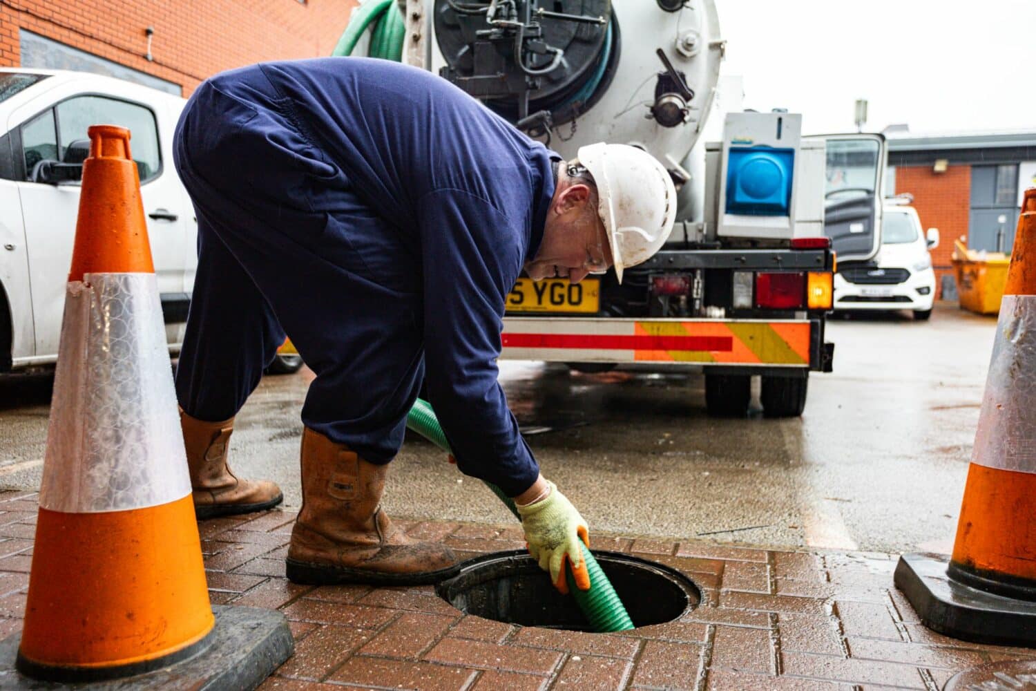 JetVac operator cleaning manhole